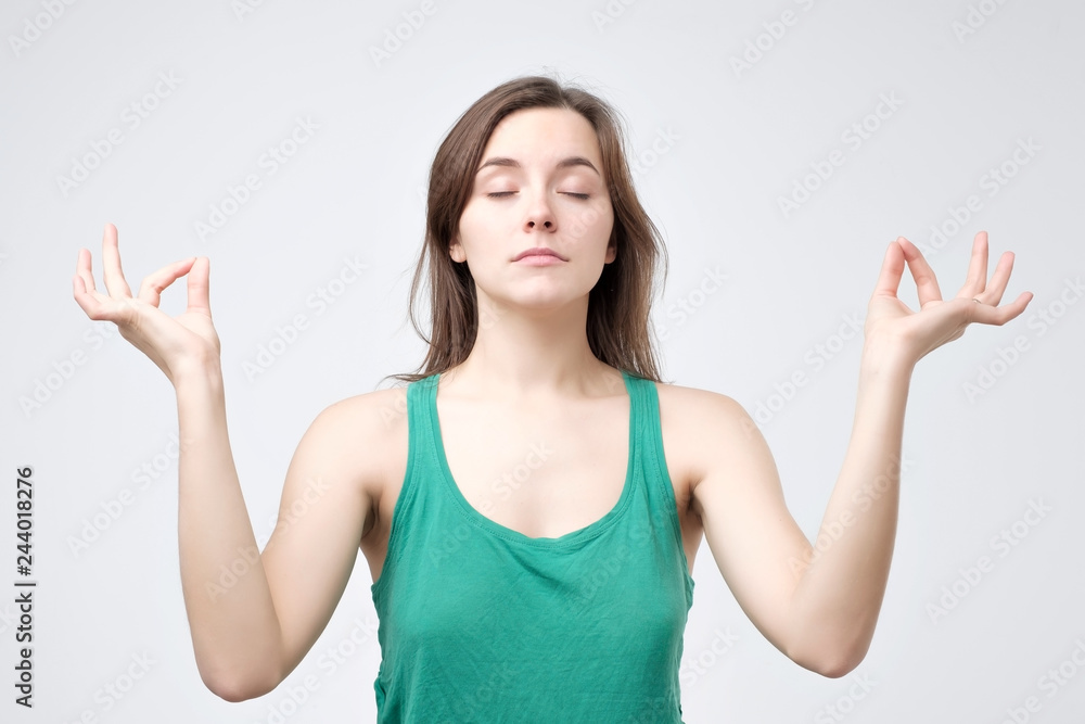Girl enjoys peaceful atmosphere, keeps hands in mudra sign Girl enjoys peaceful atmosphere, keeps hands in mudra sign
