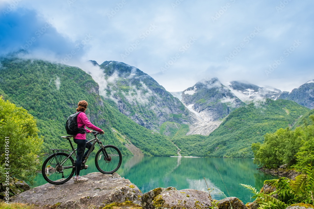 Biking woman in Norway against picturesque landscape