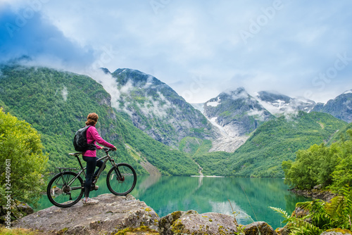 Biking woman in Norway against picturesque landscape © Kotangens