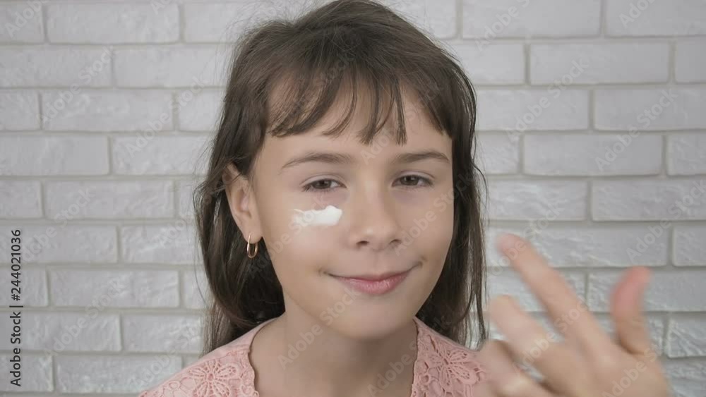 Girl moisturazing under eye skin. Little girl mom smears cream on her face. Girl moisturazing under eye skin. Little girl mom smears cream on her face.