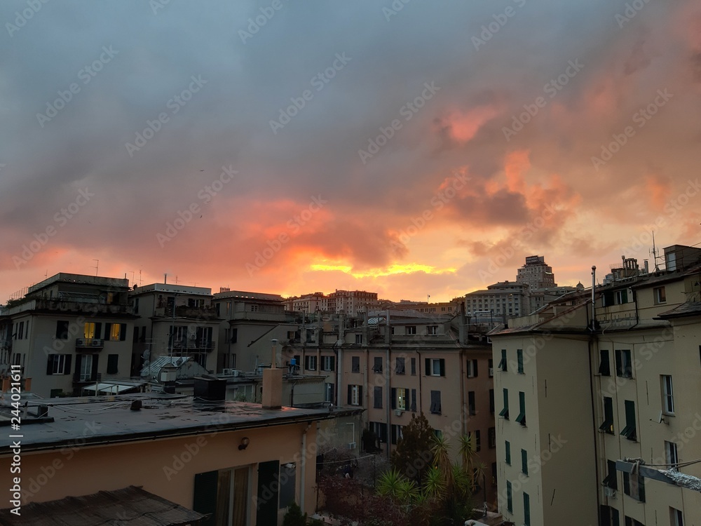 Genova, Italy - 06/17/2018: An amazing sunset over the city of genova in spring days with some clouds and great reflection over the buildings