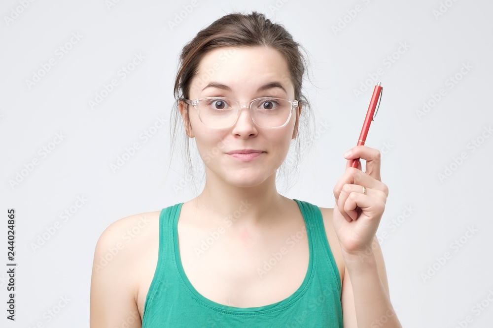 Happy blogger woman in eyeglasses having idea and looking at the camera Happy blogger woman in eyeglasses having idea and looking at the camera