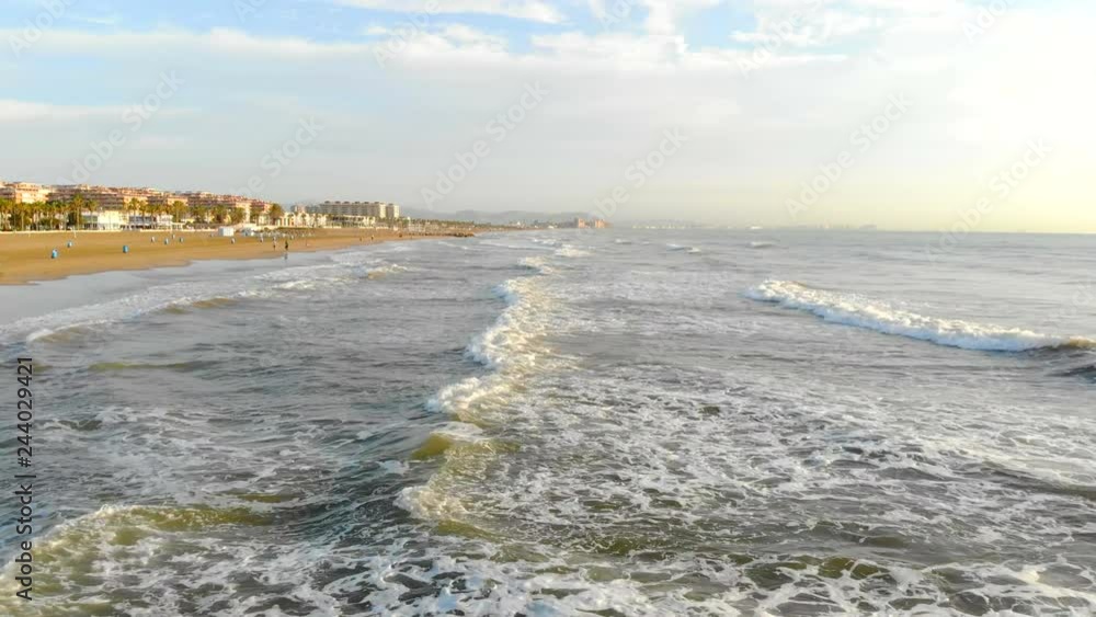 Low flight over waves coming to shore. The wave under the shade forms a large amount of foam and bubbles. Aerial Spain, the Mediterranean Sea Low flight over waves coming to shore. The wave under the shade forms a large amount of foam and bubbles. Aerial Spain, the Mediterranean Sea