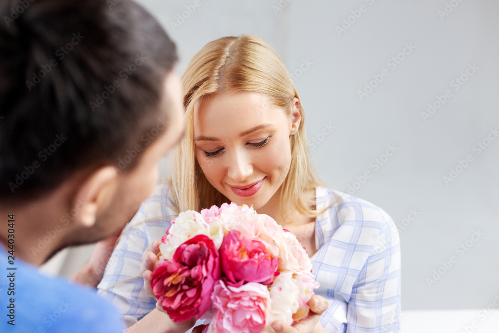 surprise, valentines day and people concept - happy couple with flowers at home surprise, valentines day and people concept - happy couple with flowers at home