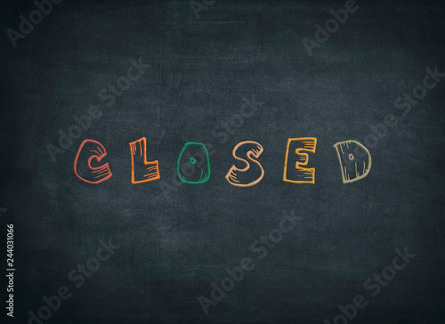 Closed sign written by color chalk on blackboard