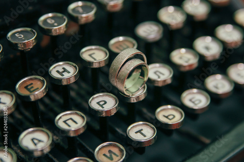Wedding rings on the typewriter. Wedding rings placed on an ancient typewriter letter buttons. 