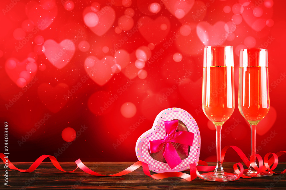 Conceptual image with two champagne flute glasses over red heart shaped bokeh lights. Romantic dinner for st Valentine's day. Close up, copy space. Colorful background for different romantic occasions Conceptual image with two champagne flute glasses over red heart shaped bokeh lights. Romantic dinner for st Valentine's day. Close up, copy space. Colorful background for different romantic occasions
