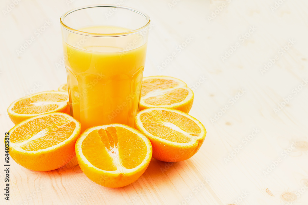 Glass of freshly pressed orange juice with sliced orange halfs Glass of freshly pressed orange juice with sliced orange halfs