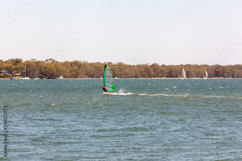 Fifty years plus male on short board windsurfing from the shores of Lake Macquarie in a summer north easterly breeze, Australia photo