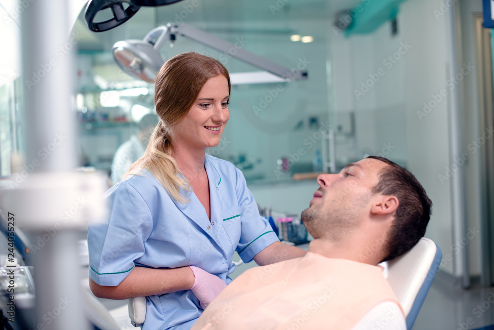 Young man talking to a dentist after dental procedure. Young man talking to a dentist after dental procedure.