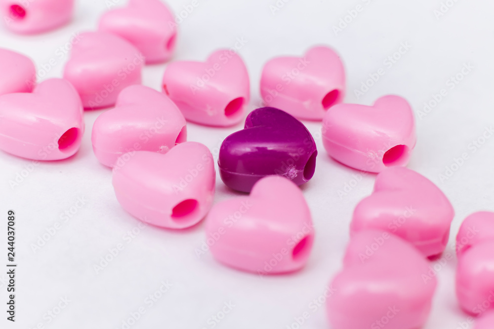 Pink beads in heart shape stacked on  table with copy space. Sweet beads for love theme on Valentine concept in vintage style.  For background or wallpaper decor. Soft Focus