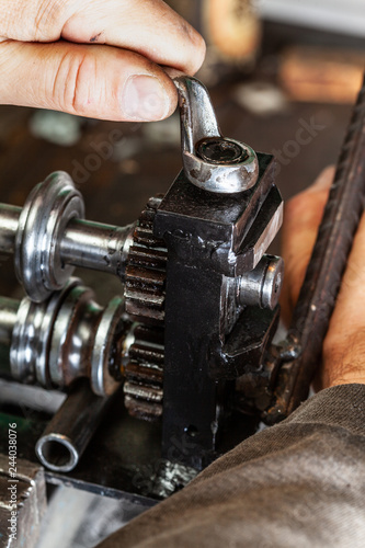 man using wrench on old machine