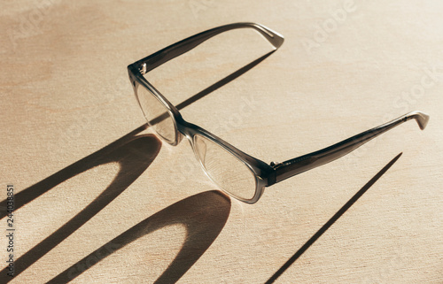 Close up of reading glasses casting long shadow photo