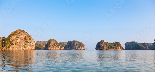 Landscape panorama of Ha Long Bay in north Vietnam. The bay consists of a dense cluster of some limestone monolithic islands each topped with thick jungle vegetation, rising from the ocean.