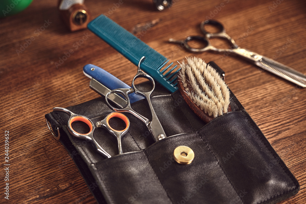 Hairdresser tools on wooden background. Top view on wooden table with scissors, comb, hairbrushes and hairclips, trimmer. Hairdresser tools on wooden background. Top view on wooden table with scissors, comb, hairbrushes and hairclips, trimmer.