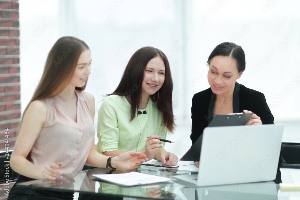 close up.three employees of the company work with documents at the table in the office close up.three employees of the company work with documents at the table in the office