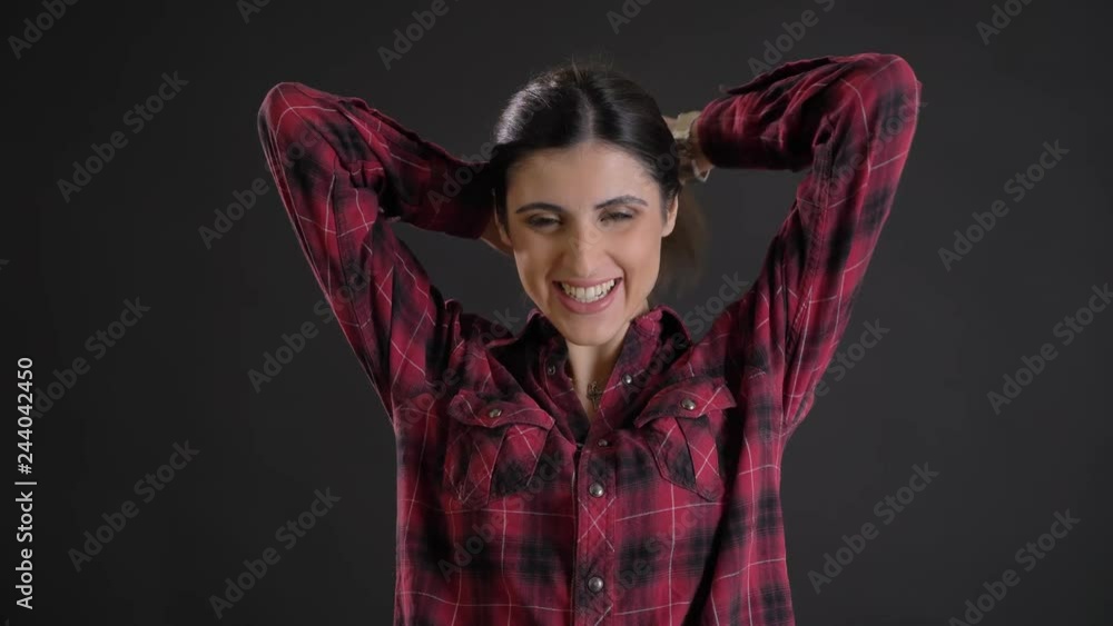 Portrait of caucasian long-haired brunette girl laughing into camera and shaking her hair on black background. Portrait of caucasian long-haired brunette girl laughing into camera and shaking her hair on black background.