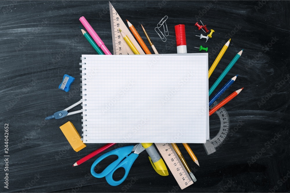 Colorful school supplies on blackboard background Colorful school supplies on blackboard background