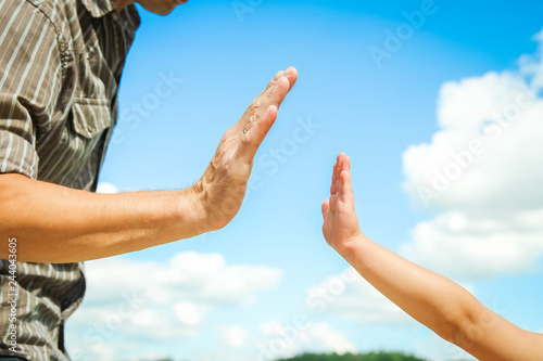 hands of a parent and child in nature in a park by the sea