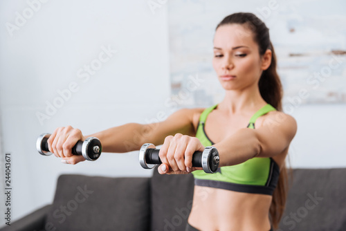 sportswoman working out with dumbbells at home with copy space