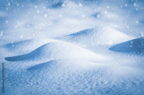 Beautiful winter background of snow drifts and falling snow © SerPhoto