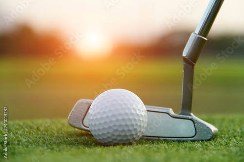 Golf ball and golf club in beautiful golf course at sunset background.