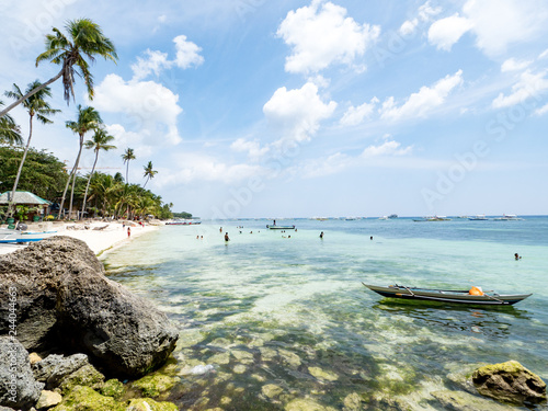 Fototapeta Naklejka Na Ścianę i Meble -  Beautiful tropical beach background from Alona Beach at Panglao Bohol island, the white sand beach with cloudy blue sky and palm trees. Travel Vacation, Philipines, november, 2018