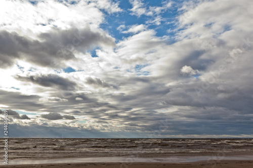 Stormy sea on a sandy beach in cloudy weather