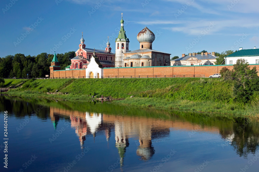 View from the river to St. Nicholas monastery with its reflection in the water. Old Ladoga.