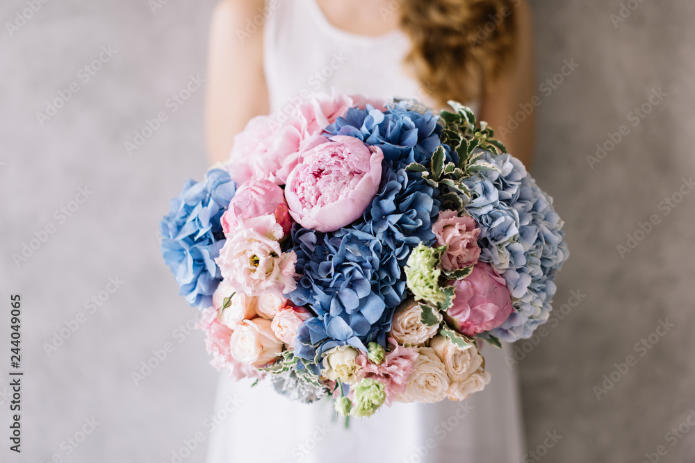 custom made wallpaper toronto digitalVery nice young woman holding beautiful blossoming bouquet of fresh hydrangea, roses, peony, eustoma, flowers in pink and blue colours on the grey wall background