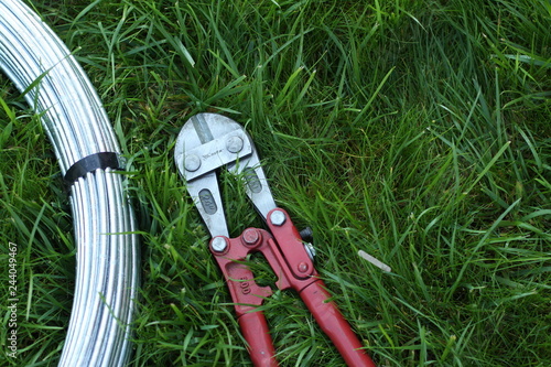 Bolt cutter near the coil wire on the grass photo
