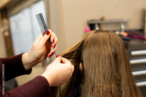 Stylist preparing brunette woman's hair for a color and highlight process