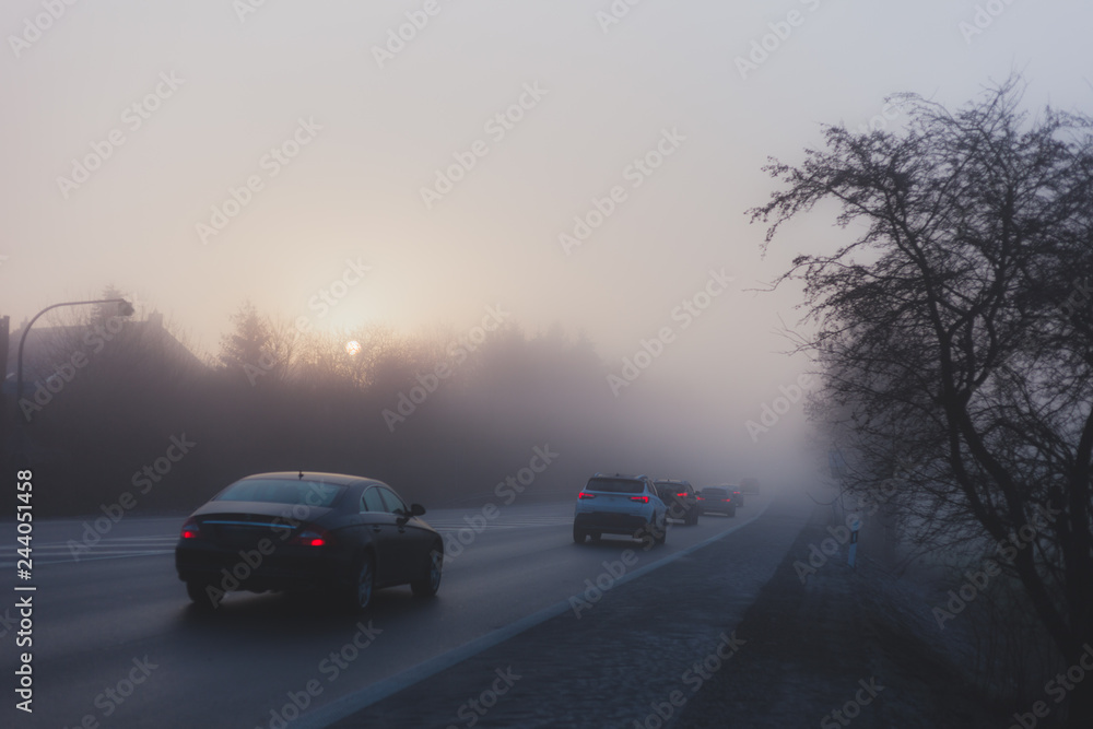 Fototapeta premium Car traffic in fog with the rising sun