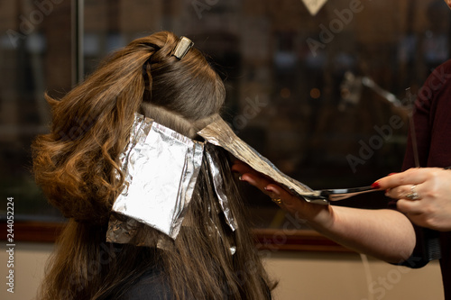 Hair color foils on a young brunette woman during a highlight process 