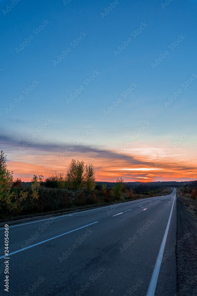 view of the road going into the distance at sunset. pink sunset