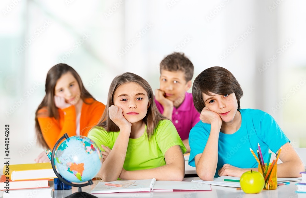 Fototapeta premium Happy children sitting by the table during lesson