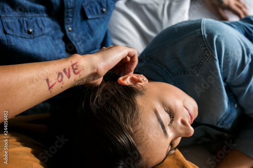Tattooed man cuddling up with girlfriend © Westend61