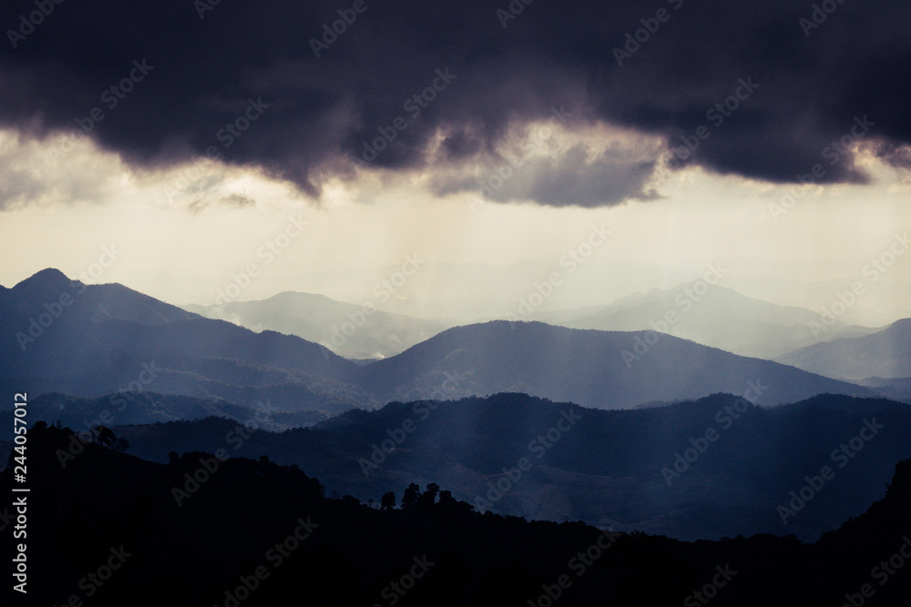 Overlapping mountains and rain clouds Overlapping mountains and rain clouds