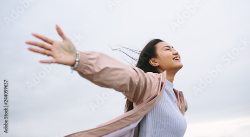 Fotografie Asian woman enjoying nature standing with open arms
