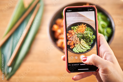 Woman taking photo poke bowl photo