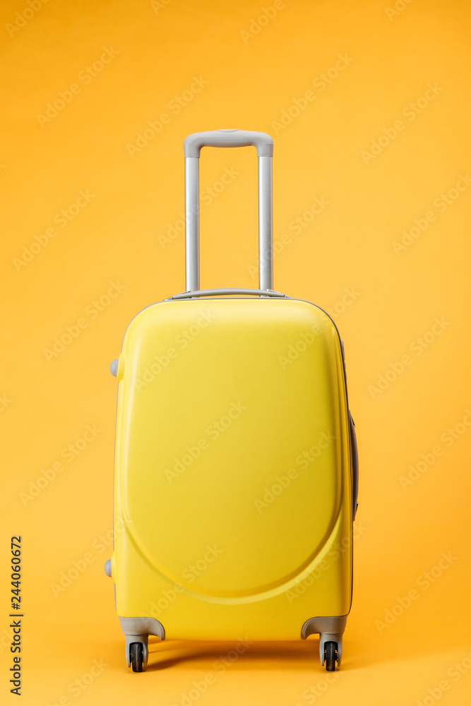 travel bag with wheels and handle on yellow background travel bag with wheels and handle on yellow background