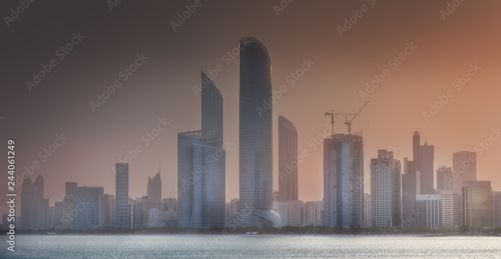 View of Abu Dhabi Skyline at misty sunrise, UAE