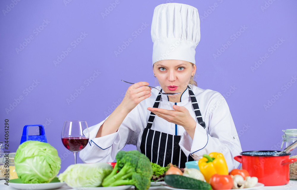 Gourmet main dish recipes. Delicious recipe concept. Girl in hat and apron. Cooking healthy food. Fresh vegetables ingredients for cooking meal. Professional cooking tips. Woman chef try taste food Gourmet main dish recipes. Delicious recipe concept. Girl in hat and apron. Cooking healthy food. Fresh vegetables ingredients for cooking meal. Professional cooking tips. Woman chef try taste food
