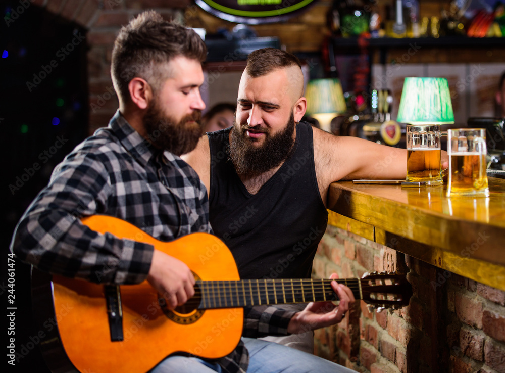 Friends relaxing in bar or pub. Real men leisure. Hipster brutal bearded spend leisure with friend in bar. Man play guitar in bar. Cheerful friends relax with guitar music. Friday relaxation in bar Friends relaxing in bar or pub. Real men leisure. Hipster brutal bearded spend leisure with friend in bar. Man play guitar in bar. Cheerful friends relax with guitar music. Friday relaxation in bar