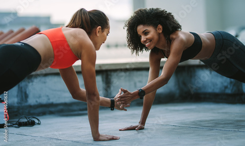 Two fitness women training together on rooftop
