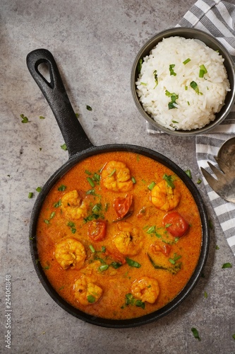 Shrimp in curry coconut sauce with rice in a bowl, overhead view