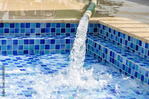 Photography filling the pool with artesian water flowing from the pipe