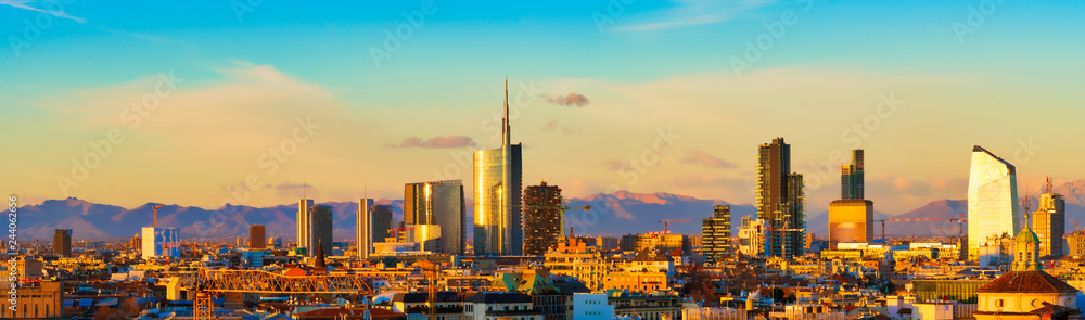 Milan skyline at sunset. Large panoramic view of Milano city, Italy. The  mountain range of the Lombardy Alps in the background. Italian landscape.  Stock Photo