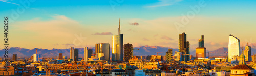  Milan skyline at sunset. Large panoramic view of Milano city, Italy. The mountain range of the Lombardy Alps in the background. Italian landscape.