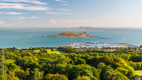 Irish landscape as seen from the Ben of Howth with green trees, turquoise sea waters and Ireland's Eye Island in the distance on a beautiful summer day. photo
